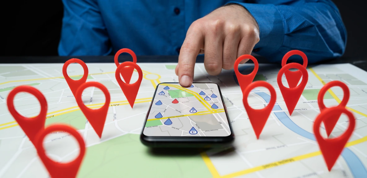 Mann sucht Entrümpelungsunternehmen in der Nähe über Smartphone-Karte mit Standort-Pins