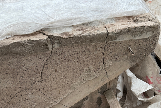 Betonschornstein mit deutlichen Rissen nach 48 Stunden Betonamit-Einwirkung, Folie als Abdeckung.